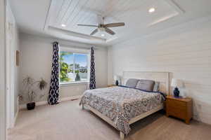 Carpeted bedroom featuring a tray ceiling, recessed lighting, and a ceiling fan