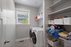 Laundry room featuring independent washer and dryer and light tile patterned floors