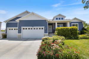 Craftsman-style home featuring a garage, driveway, and a front yard