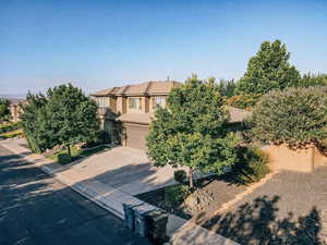 Obstructed view of property featuring driveway, a garage, a tiled roof, and stucco siding