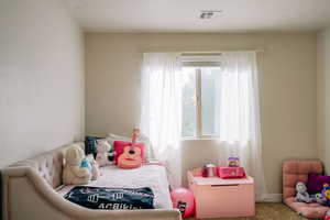 Bedroom with multiple windows and carpet