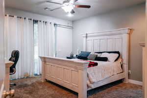 Carpeted bedroom featuring ceiling fan