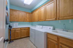 Washroom featuring cabinet space, independent washer and dryer, and light tile patterned floors