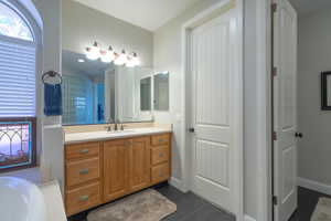 Bathroom with vanity, wood finished floors, plenty of natural light, and a bath
