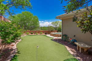 Fenced backyard with a putting green