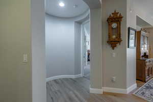 Hallway featuring light wood-style flooring and arched walkways