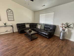 Living room with lofted ceiling, wood finished floors, and ceiling fan
