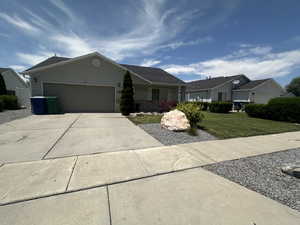 Single story home featuring concrete driveway, a garage, a front yard, and brick siding