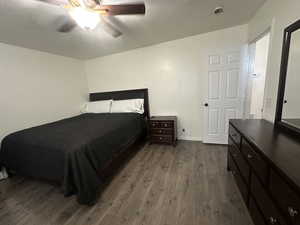 Bedroom with dark wood-style floors and a ceiling fan