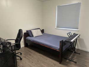 Bedroom with wood finished floors and baseboards