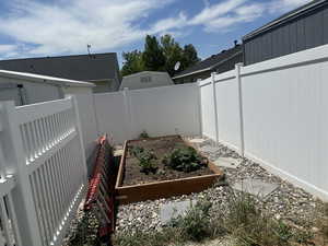 Fenced backyard featuring a vegetable garden
