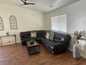 Living area with a ceiling fan and wood finished floors