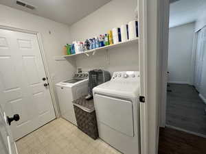 Laundry area with independent washer and dryer and light floors