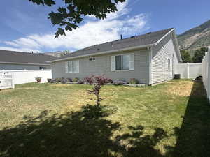 Rear view of property featuring a fenced backyard and a mountain view