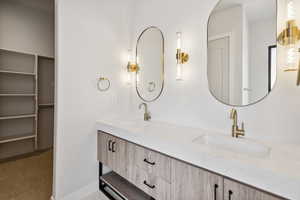Full bath with double vanity and a spacious closet