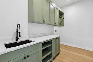Laundry room featuring cabinet space, light wood-type flooring, and washer hookup
