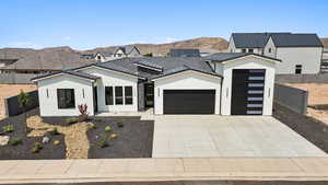 Modern inspired farmhouse featuring a garage, stucco siding, driveway, and a tile roof