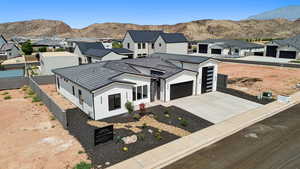 Modern farmhouse style home featuring concrete driveway, a residential view, stucco siding, and a mountain view