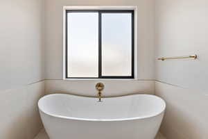 Full bath featuring plenty of natural light and a freestanding bath
