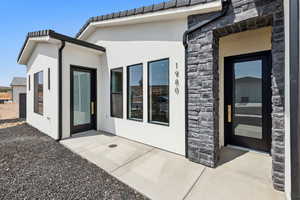 Rear view of property with stone siding and stucco siding