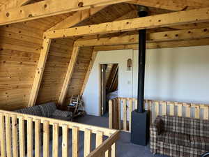 Carpeted bedroom with a wooden ceiling with exposed beams