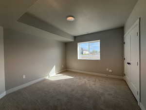 Unfurnished bedroom featuring light colored carpet and baseboards