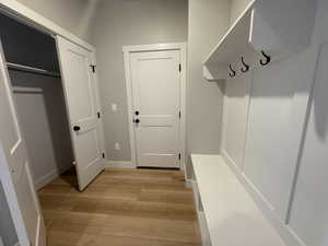 Mudroom with light wood finished floors and baseboards