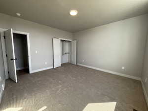 Unfurnished bedroom featuring carpet flooring and a closet