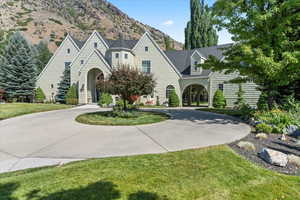 View of front of house featuring curved driveway, a front yard, and a mountain view