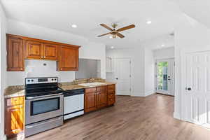 Kitchen with electric stove, dishwasher, ceiling fan, brown cabinetry, and recessed lighting