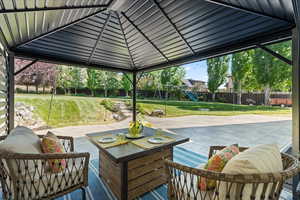 Fenced backyard featuring a playground, a patio, and an outdoor hangout area