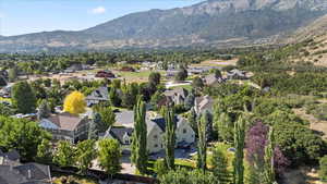 Aerial view of property and surrounding area featuring nearby suburban area and mountains