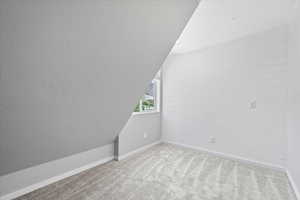 Bonus room with carpet and lofted ceiling