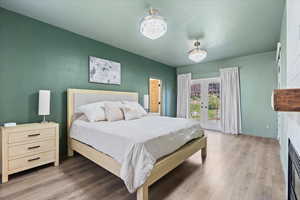 Bedroom with french doors, wood finished floors, and access to exterior