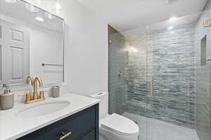 Full bath featuring a stall shower and vanity