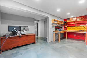 Office featuring a workshop area, concrete flooring, and recessed lighting