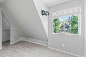 Additional living space featuring carpet floors and baseboards