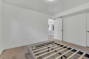 Unfurnished bedroom with carpet floors and baseboards