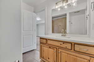 Full bathroom featuring vanity, tile patterned flooring, and a shower