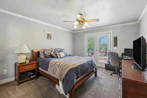 Bedroom with access to exterior, carpet floors, a desk, crown molding, and ceiling fan