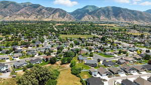 Aerial view of property and surrounding area with mountains and nearby suburban area
