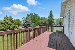Wooden terrace featuring a yard