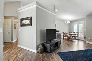 Living room with wood finished floors, a chandelier, and recessed lighting