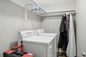 Washroom featuring washing machine and dryer and baseboards
