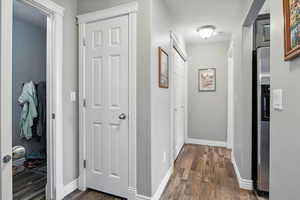 Corridor featuring dark wood finished floors and baseboards
