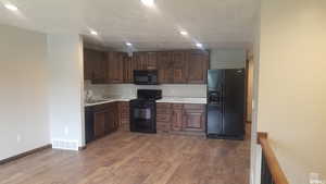 Kitchen with black appliances, light countertops, light wood-style floors, and recessed lighting
