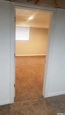 Spare room featuring carpet flooring and baseboards