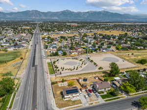 Aerial view of property and surrounding area featuring a mountain backdrop and nearby suburban area