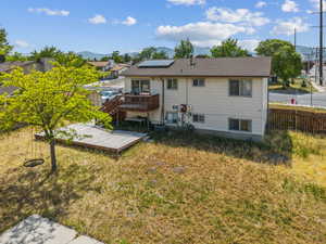 Rear view of house featuring a deck with mountain view and solar panels