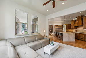 Living area featuring arched walkways, a ceiling fan, recessed lighting, and wood finished floors